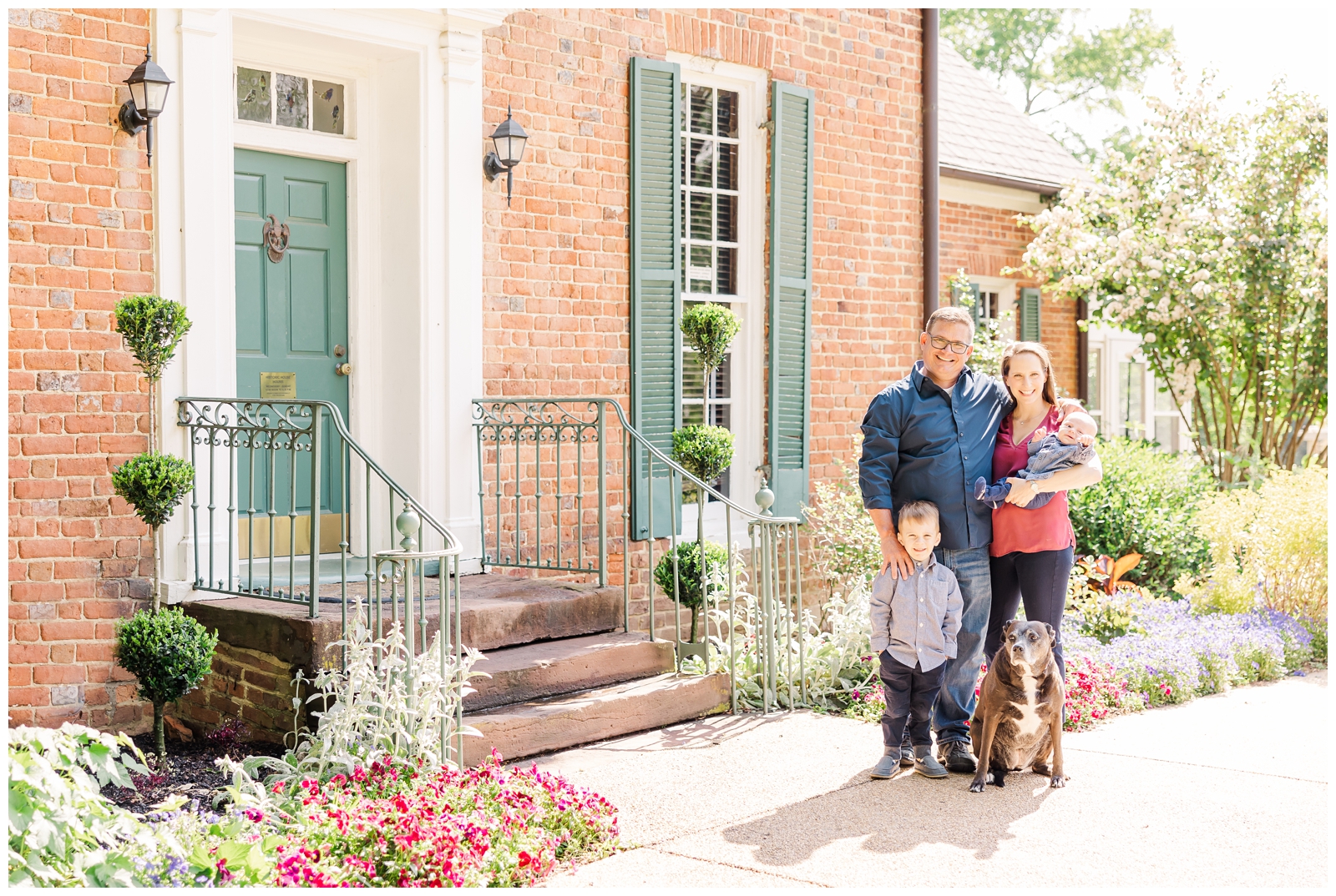 Family and dog standing in front of Historic House at Green Spring Gardens