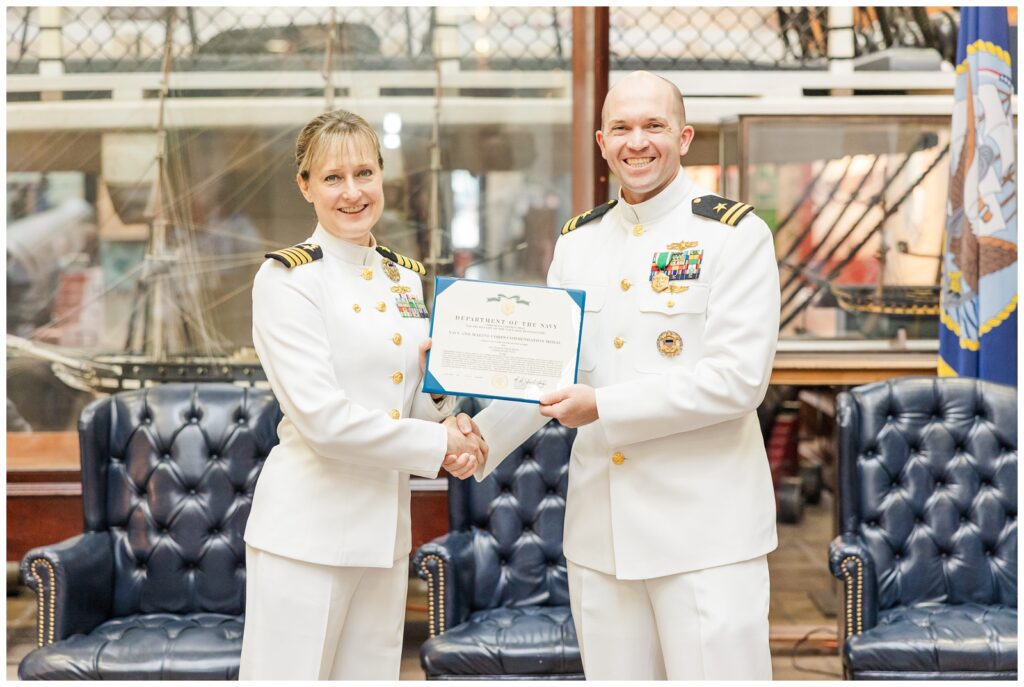 Navy officers posing with retirement certificate