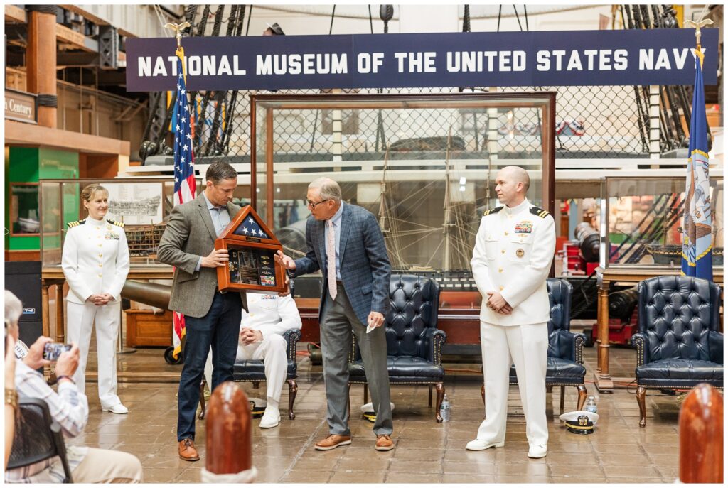 Navy family presenting service member with a shadow box