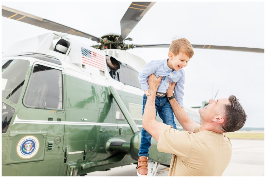 Dad holding his son in front of Marine One aircraft