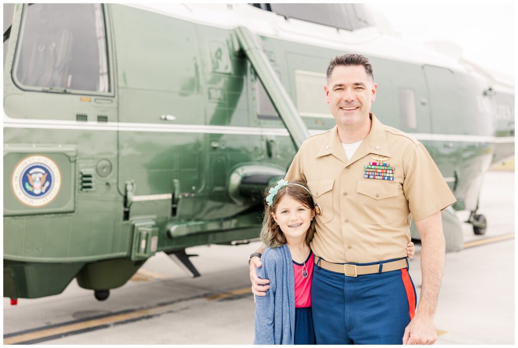 Dad and daughter standing in front of a helicopter