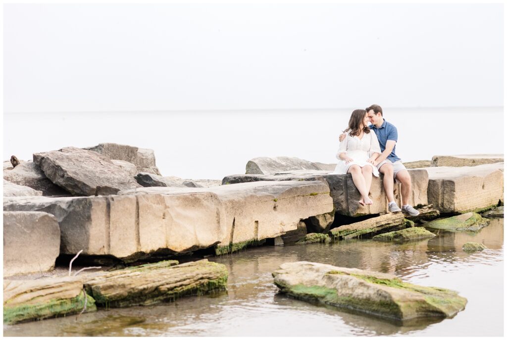 Couple sitting on the rocks on the shore of Lake Erie