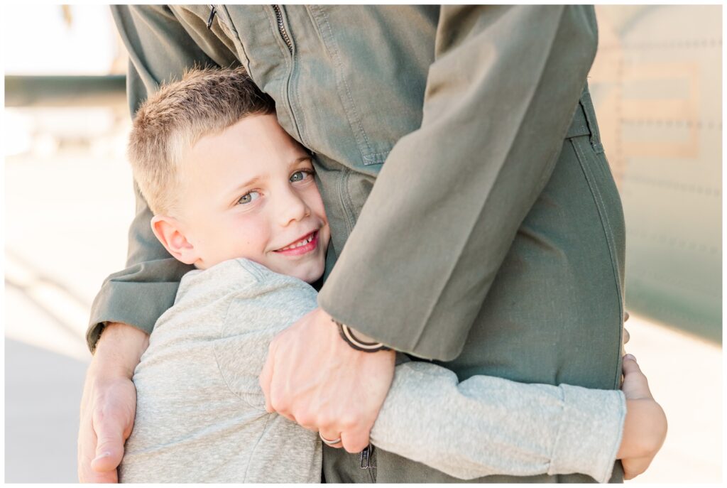 Military kid hugging his dad in uniform