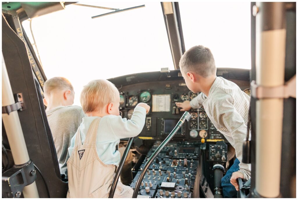 Air Force kids playing in the cockpit of a Huey during flight line family photos