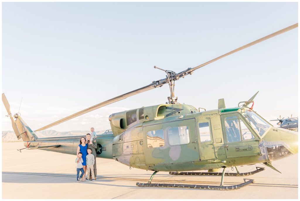 Air Force family smiling with the Huey during flight line family photos