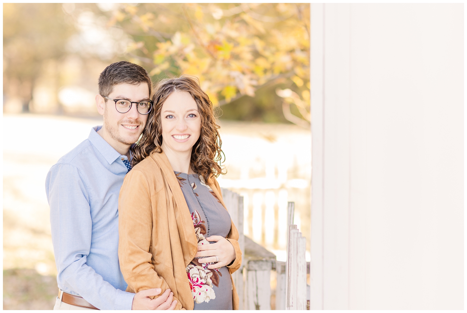 Expecting couple smiling at the camera during their session with Erin Thompson, an Alexandria maternity photographer.