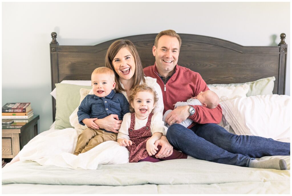 Whole family of five sitting on a bed