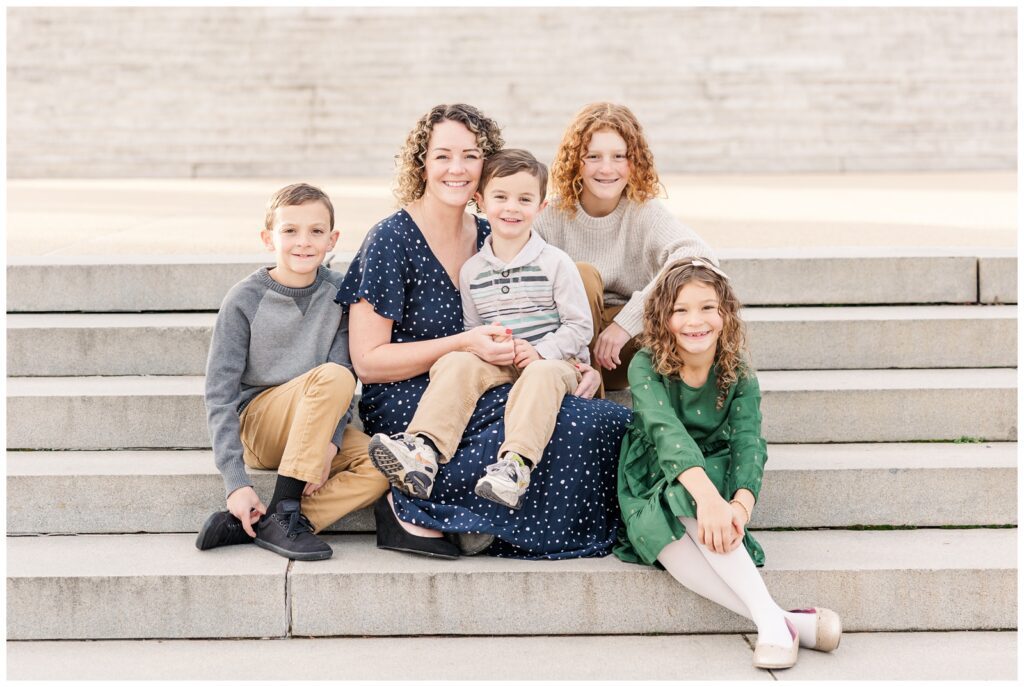 Mom sitting and smiling with her four children during their Jefferson Memorial family session