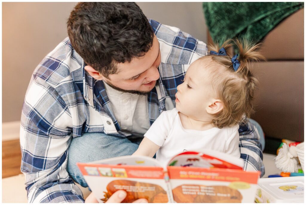 Daddy and daughter reading a book together during Alexandria lifestyle photography session