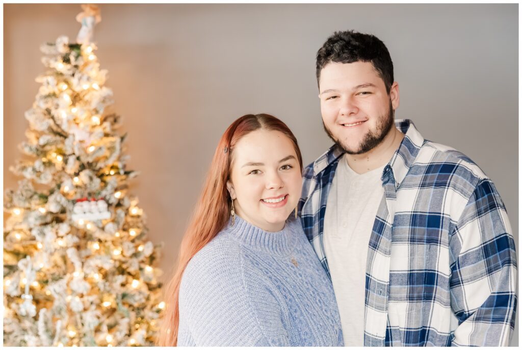 Couple standing in front of their Christmas tree