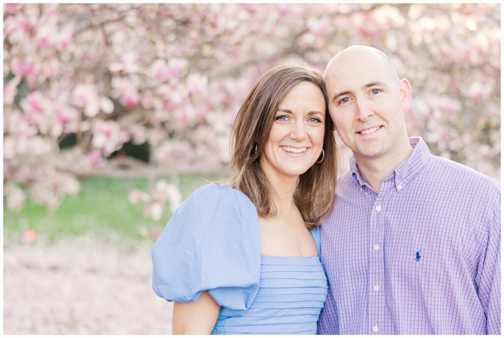 Parents smiling in front of a magnolia tree