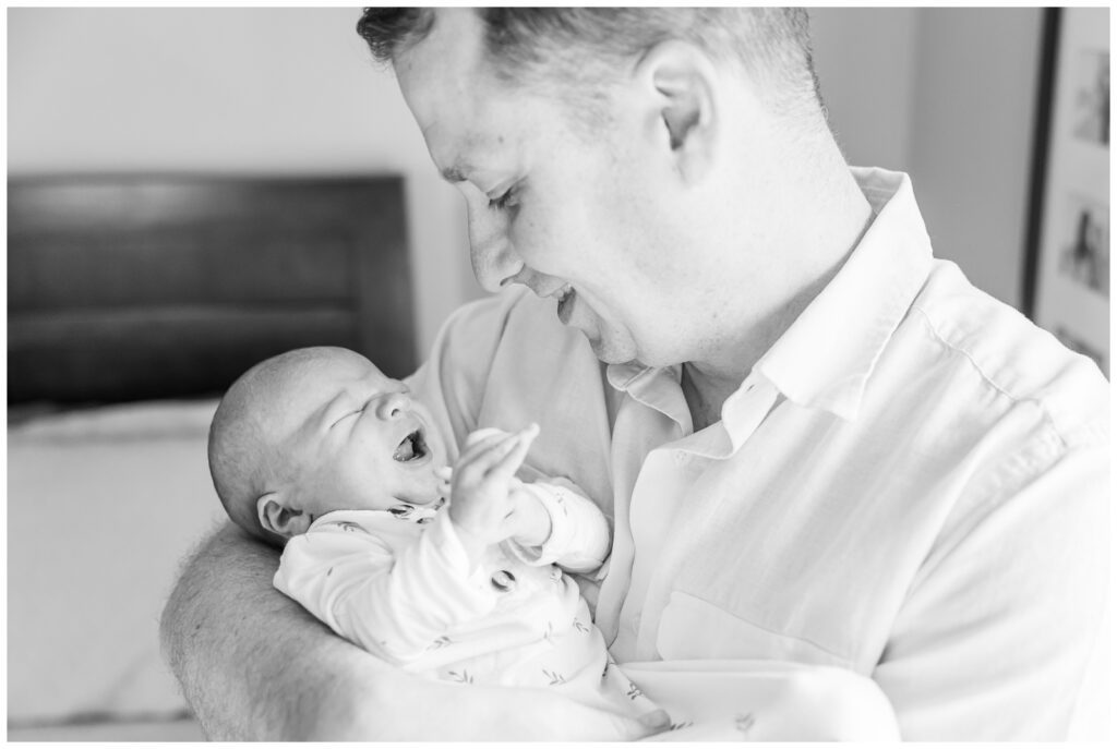 Black and white of dad looking down at newborn son