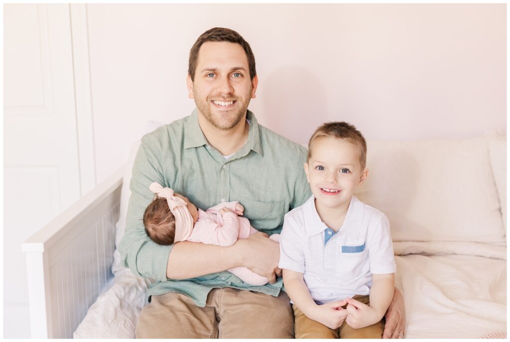 Dad smiling with his two children, captured by Erin Thompson, Virginia newborn photographer