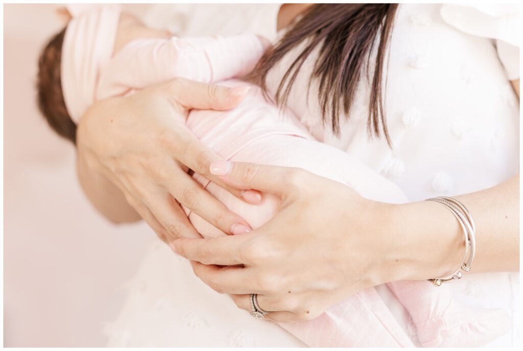 Closeup of mom's hands holding baby girl, captured by Erin Thompson, Virginia newborn photographer