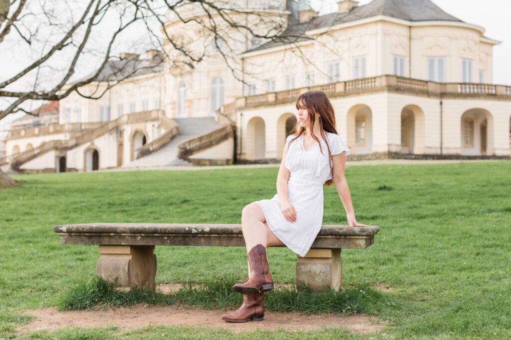Teenage girl sitting on a bench in front of a beautiful building at Schloss Solitude in Joanie Zipperer Photography's Stuttgart, Germany photography spotlight