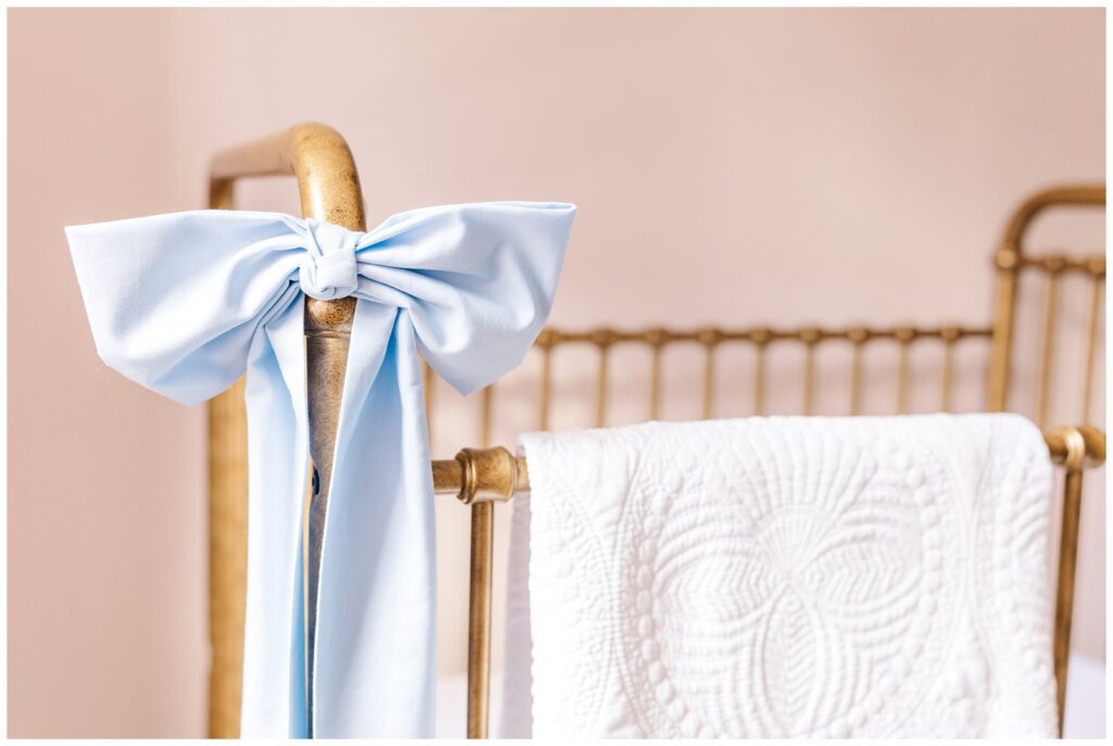 Blue bow tied on the corner of baby's crib