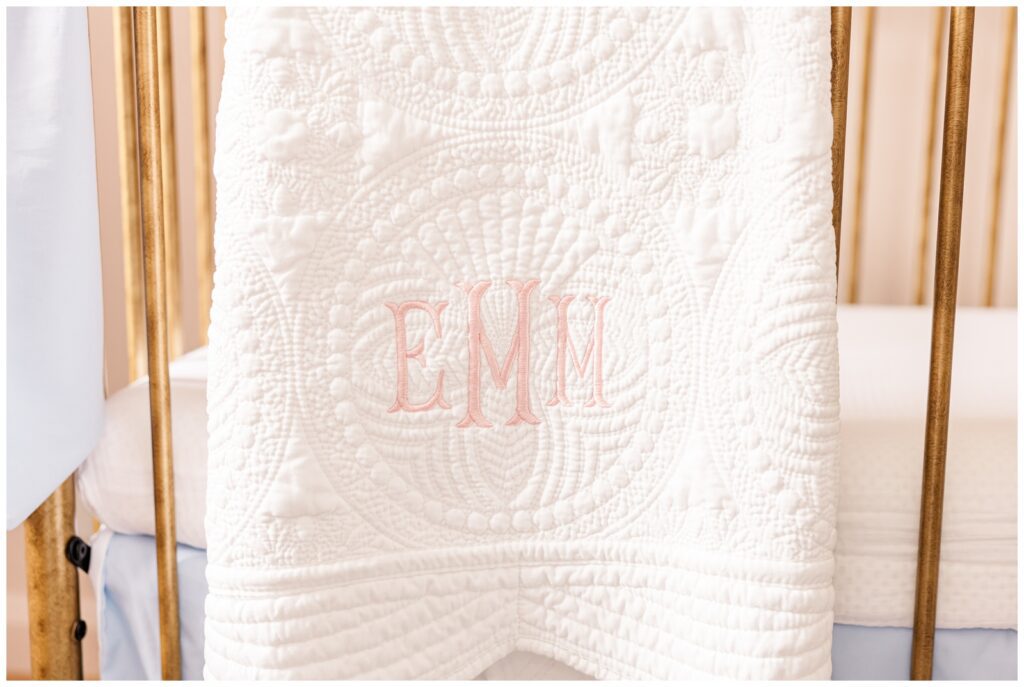Embroidered quilt hanging the baby's crib