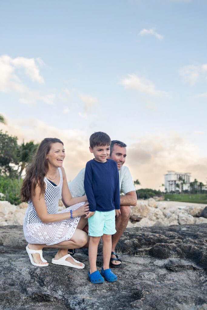 Parents smiling with their little boy at Paradise Cove Beach in Kelly Stewart Photography's Mililani, HI photography spotlight