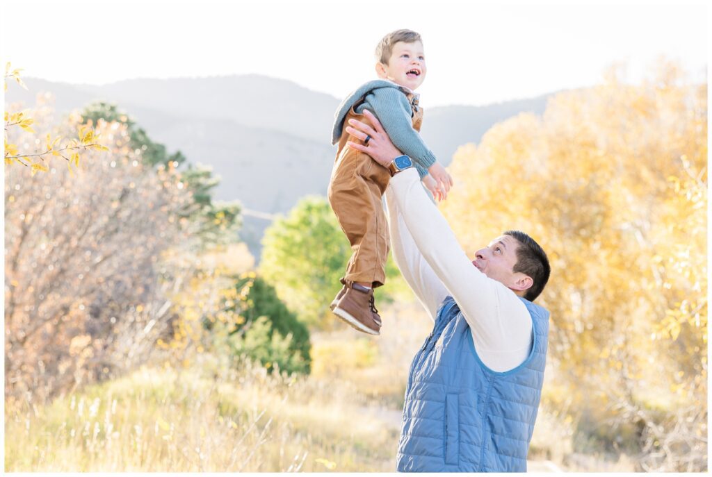 Dad tossing son up in the air with Monument, CO family photographer