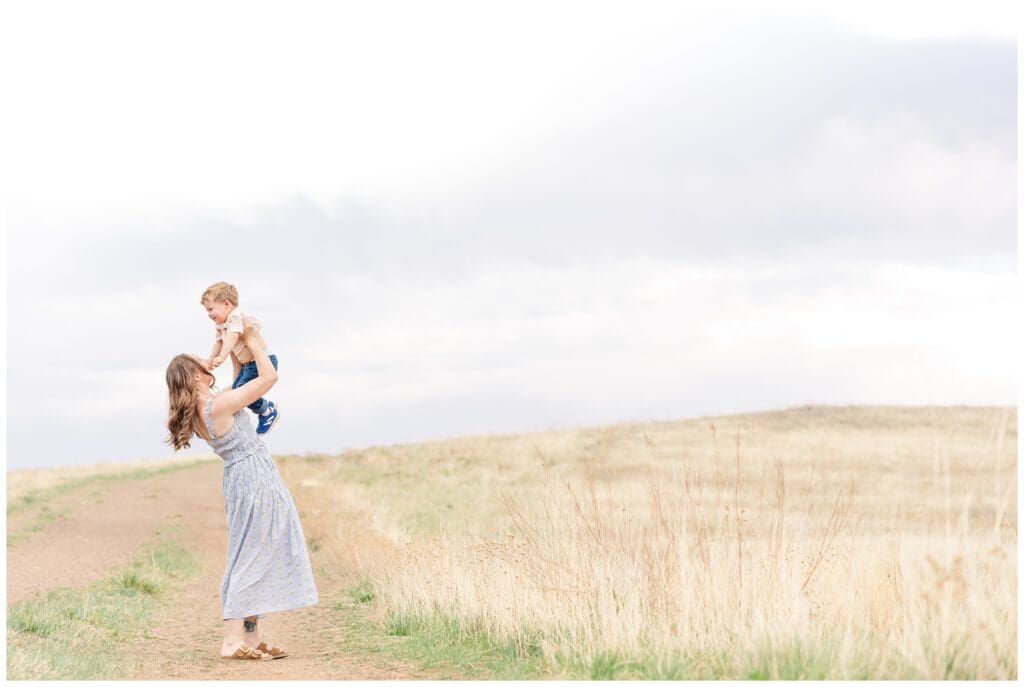 Mom holding toddler son up in the air