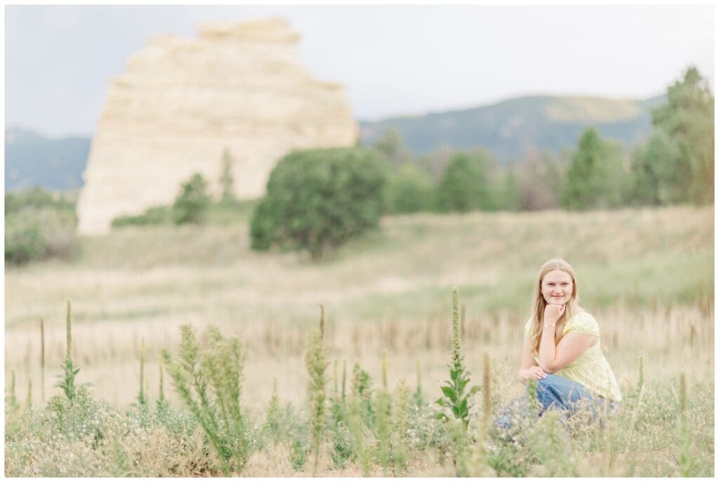 Senior girl in the foothills in front of Monument Rock getting her Colorado Springs senior photos